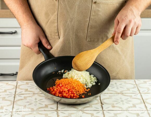 Нарежьте лук, перец и морковь мелким кубиком и обжарьте на оливковом масле в течение 5 минут.