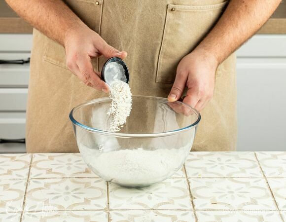 Просейте муку вместе с разрыхлителем в глубокую миску. Сделайте углубление.