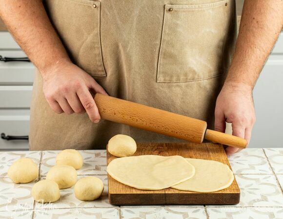 Разделите тесто на 8 шариков, каждый раскатайте в лепешку толщиной 3 мм.