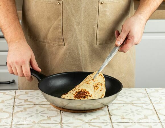 Разогрейте в сковороде с толстыми стенками масло — оно должно полностью покрывать дно. Положите лепешку и, вращая сковородку по кругу, обжарьте лепешку до румяной корочки. Переверните и обжарьте с другой стороны.