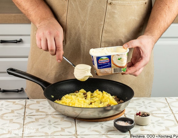 Добавьте плавленый сыр Hochland «Сливочный». Посолите и поперчите.