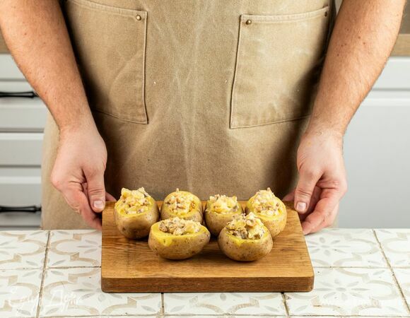 Нафаршируйте начинкой картофель и украсьте мелко нарезанной зеленью.