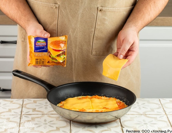 Сбрызните нагретую сковороду маслом. Влейте половину яичной смеси. Через пару минут, когда масса дойдет до полуготовности, выложите на нее ломтики плавленого сыра Hochland «Чизбургер».