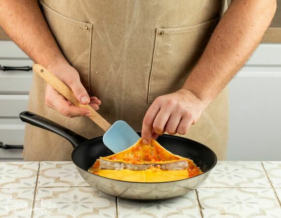 Сверху распределите креветки. С помощью двух лопаток начните аккуратно заворачивать рулет.