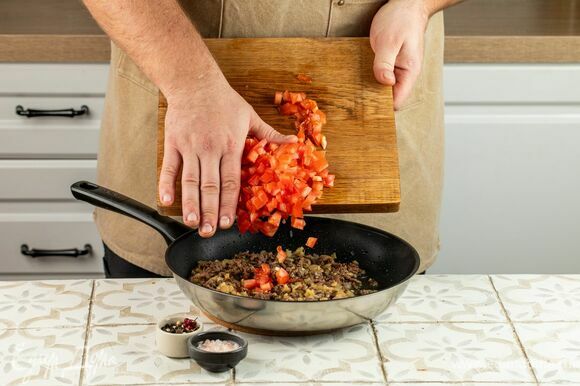Разогрейте сковороду. Последовательно выложите лук, затем мякоть баклажанов, затем мясной фарш и помидоры. Посолите, поперчите и обжаривайте смесь в течение 5 минут, затем снимите с огня и остудите.