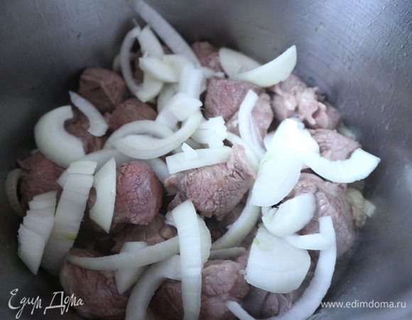 Положить баранину. Перемешать несколько раз в течение 5–6 минут. Добавить репчатый лук.