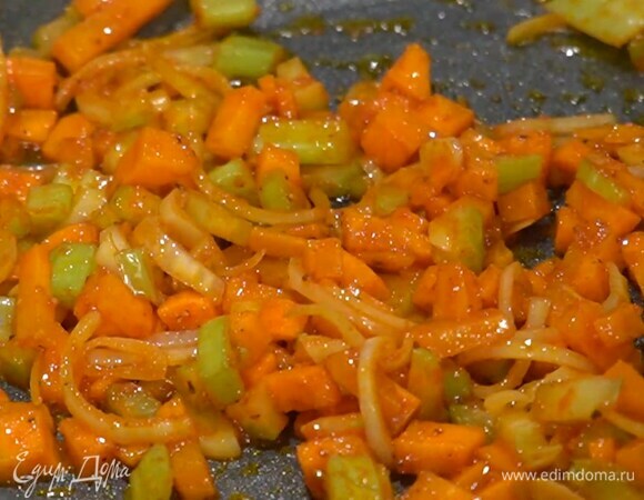 Разогреть в сковороде растительное масло, выложить морковь, лук, сельдерей и чеснок, добавить томатную пасту и чили, все слегка посолить, поперчить, перемешать и обжаривать до прозрачности, непрерывно помешивая первые несколько минут.