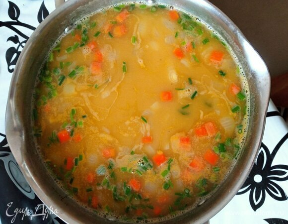 Мелко шинкуем петрушку и зеленый лук. Стебельки петрушки отправляем в суп. Варим еще 5 минут до готовности овощей и риса.