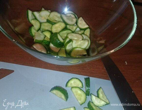 Беремся за огурцы. Режем кружками толщиной 5 миллиметров и потом пополам. Нарезали — в салатницу!