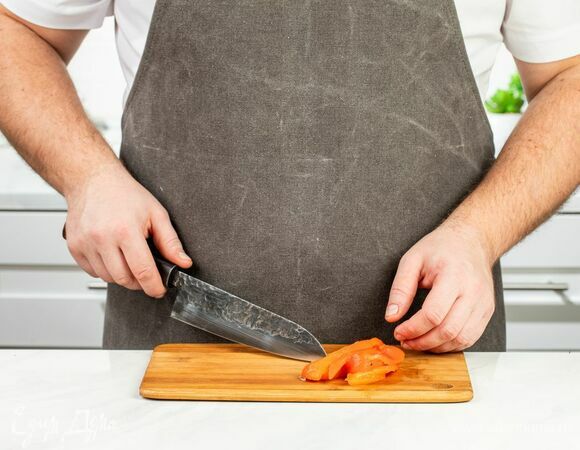 Остывший перец очистите от кожи и семян, нарежьте соломкой.