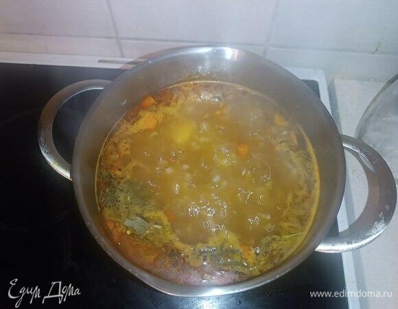 В кастрюлю следом отправляем чеснок, маслины, специи и приправу рыбную, лавровый лист. Накрываем крышкой и варим около 5 минут.