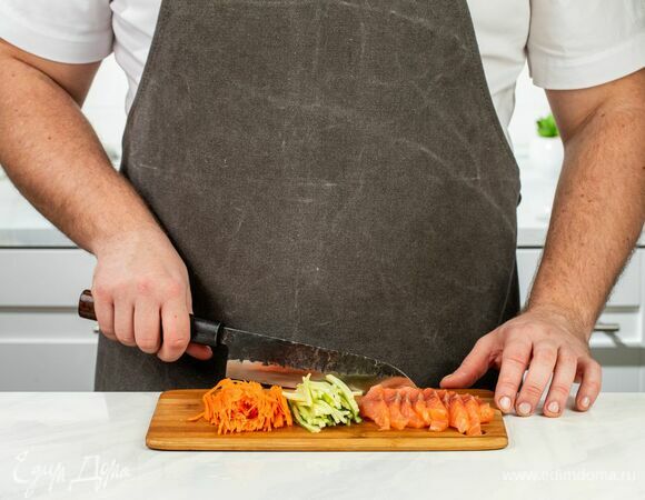 Морковь и огурец нарежьте соломкой, а рыбу — тонкими слайсами.