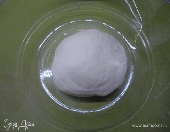 Муку смешать с дрожжами, сахаром и солью. Влить теплую воду. Хорошо перемешать, пока не сформируется упругое, но достаточно влажное тесто. Затем переложите тесто на посыпанную мукой рабочую поверхность и начинайте месить интенсивно, растягивающими движениями. Минут 10–15, пока тесто не станет более эластичным и гладким. Смажьте оливковым маслом и оставьте в тепле на 3 часа.