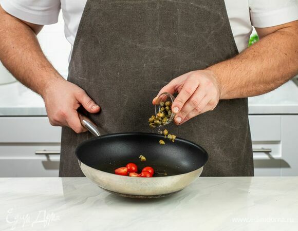 Томаты черри разрежьте пополам и слегка обжарьте на сковороде пару минут вместе с каперсами.