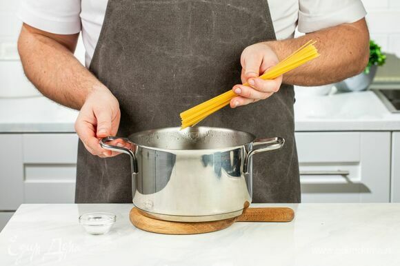 Спагетти опустите в кипящую подсоленную воду и варите на минуту меньше, чем указано на упаковке. Слейте жидкость, оставив пару столовых ложек.