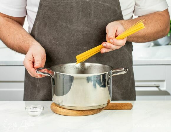 Спагетти опустите в кипящую подсоленную воду и варите на минуту меньше, чем указано на упаковке. Слейте жидкость, оставив пару столовых ложек.
