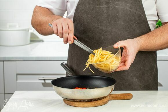 Добавьте спагетти в сковороду к помидорам с каперсами, перемешайте.