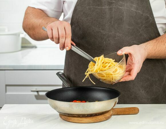 Добавьте спагетти в сковороду к помидорам с каперсами, перемешайте.