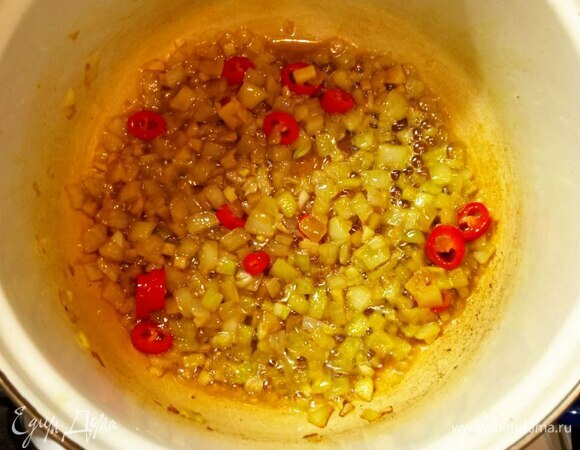 Мелко шинкуем лук, чеснок и имбирь. Перец чили нарезаем кольцами. Несколько колец оставляем для подачи. В кастрюле в разогретом растительном масле обжариваем лук пару минут, добавляем имбирь, чеснок и перец чили. Приправляем мускатным орехом, паприкой и куркумой. Обжариваем еще пару минут.