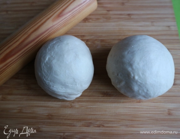 Разделить тесто на 2 части, скатать два шара. Посмотрите, как поменялась текстура теста после того, как оно постояло и отдохнуло. С одним куском теста надо работать, другой убрать в сотейник, накрыть полотенцем.