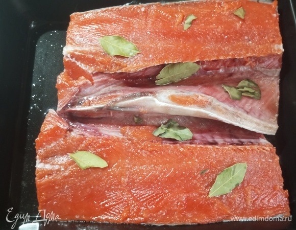 Рыбу очистить от чешуи. Разрезать пополам вдоль по хребту. Уложить в емкость кожей вниз. Дно посуды и рыбу посыпать солью. Положить лавровый лист. Полить рыбу растительным маслом. Закрыть емкость и убрать в холодильник на ночь.