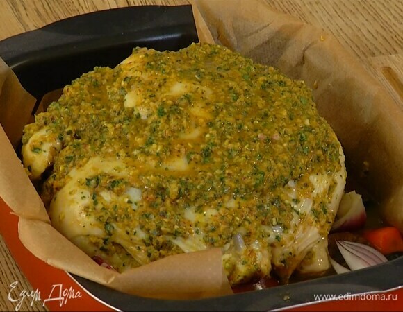 Глубокий противень застелить бумагой для выпечки, выложить морковь, оставшийся лук, чернослив, курагу, инжир, сверху поместить курицу и весь маринад, влить 300–400 мл воды.