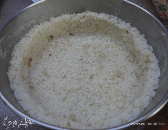 Разъемную форму диаметром 18–20 см смазать сливочным маслом и обсыпать мукой. Из риса сформовать форму пирога — дно и бортики.
