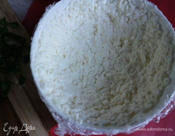 В белки добавить немного заправки от общего количества, перемешать. Миску с закругленным дном слегка смазать оливковым маслом, пищевую пленку смазать оливковым маслом с одной стороны. Поместить пленку в миску (концы пленки должны свисать с миски, так удобнее будет вынимать селедку под шубой из миски), смазанная маслом сторона должна соприкасаться с натертыми белками. Белки надо поместить по всей внутренней поверхности миски тонким слоем.