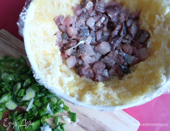 На этот слой поместить часть картофеля, в который так же добавлена заправка. Картофель должен располагаться тонким слоем по всей внутренней поверхности миски. Следующий слой — сельдь, часть сельди оставить на другой слой. Сельдь расположить только по нижней части (бока миски не прикрывать).