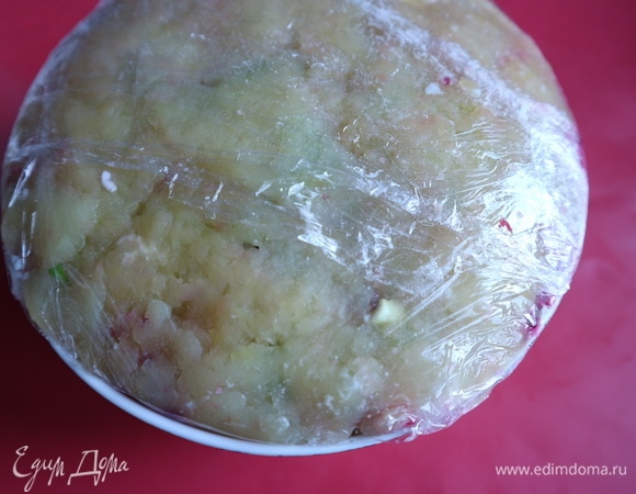 Немного оставшейся сельди, зеленый лук и лук-шалот, сверху — тонкий слой картофеля, заправку в него не добавлять. Утрамбовать слегка. Закрыть пленкой верх миски. Убрать в холодильник на 1–2 часа.