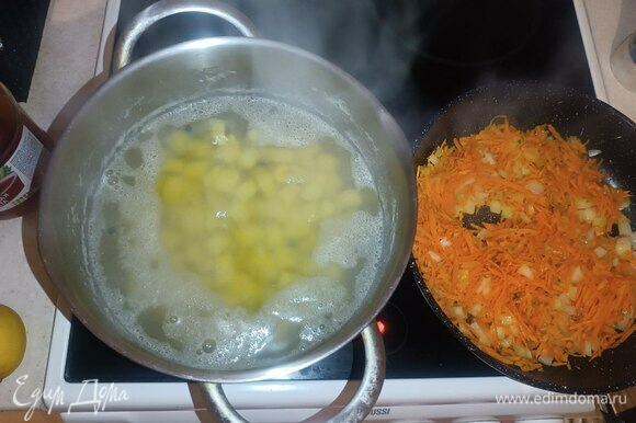 В кастрюлю с картошкой добавляем душистый перец горошком. В разогретой сковородке с растительным маслом обжариваем лук и морковь около 3 минут.