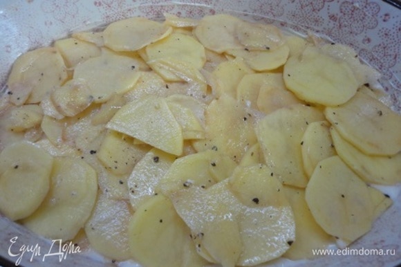 Включите духовку для разогрева на 170–180°C. Форму смазать маслом, вылить половину теста и выложить картофель.