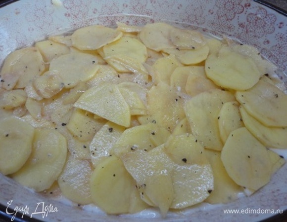 Включите духовку для разогрева на 170–180°C. Форму смазать маслом, вылить половину теста и выложить картофель.