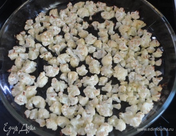 Цветную капусту разобрать на соцветия, выложить в один слой в форму для запекания, полить маслом и запекать в режиме «Гриль» 15 минут, до подрумянивания.