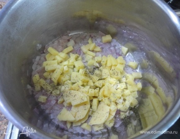 Лук нарезать мелкими кубиками и тушить до мягкости в кастрюле с толстым дном 5 минут. Картофель нарезать кубиками, чеснок порубить и выложить к луку, добавить тимьян и муку и обжаривать 2–3 минуты, помешивая.