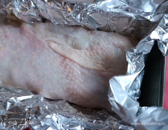 В форму поместить фольгу таким образом, чтобы часть ее выступала из формы. На фольгу поместить кожу от куриных грудок, она должна полностью закрывать фарш. Кожа служит дополнительным барьером от пересыхания и помогает держать форму приготовленному блюду. Равномерно положить фарш в форму, накрыть куриной кожей сверху, смазать поверхность оливковым маслом, затем накрыть фольгой. Поместить в духовку на 1 час 5 минут. Вам может понадобиться чуть меньше или больше времени.