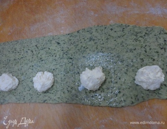 Тесто раскатать полосками. Начинку выложить по чайной ложке с интервалом 10 см. Между начинкой тесто намазать белком и сверху накрыть другим пластом теста.
