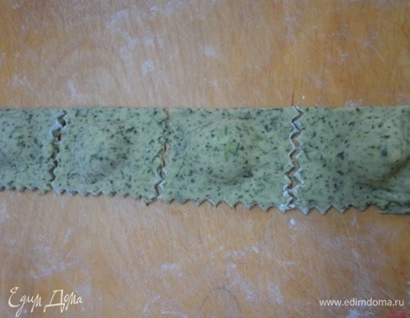 Пласты теста плотно сжать при помощи салфетки. После этого колесиком для теста вырезать равиоли.