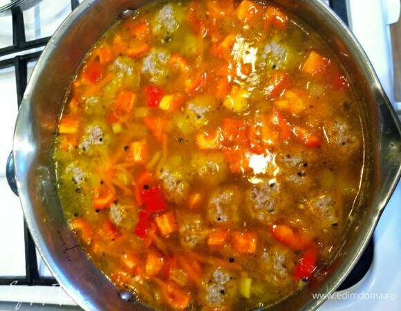 В овощи добавить перец, обжарить минуту и залить горячей водой. У меня кастрюля 3,5 литра. Воды добавила примерно 2,7 литра. Когда закипит, добавляем нарезанный кубиком картофель и фрикадельки. Варим 10 минут.