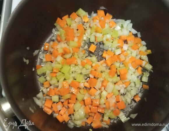 Мелко шинкуем лук, стебель сельдерея и морковь. В сотейнике разогреваем оливковое масло. Кладем овощи и обжариваем на среднем огне минуты 2.