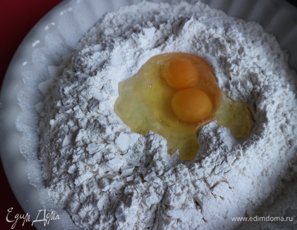 В углубление в центре муки добавить яйца.
