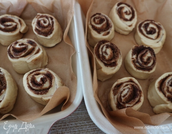 Духовку разогреть до 180°C. Нарезать тесто острым ножом на 12 частей. Поместить в форму, покрытую пекарской бумагой, разрезом вверх на значительном расстоянии друг от друга. Булочки будут увеличиваться в размере (пока постоят и при выпечке). Дать постоять минут 25–30 под полотенцем.