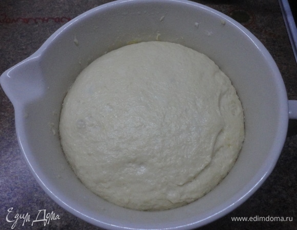 Теплую воду смешать с остальными ингредиентами. Хорошо перемешать, пока не сформируется упругое, но достаточно влажное тесто. Переложите тесто на посыпанную мукой рабочую поверхность и начинайте месить растягивающими движениями, пока тесто не станет более эластичным и гладким. Смажьте тесто оливковым маслом, накройте пищевой пленкой и оставьте в холодильнике на ночь (или даже дольше). В холодном месте тесто также подойдет, только медленнее. Но вкус его от такой длительной ферментации будет значительно лучше. Тесто достать из холодильника по крайней мере за 20–30 минут.