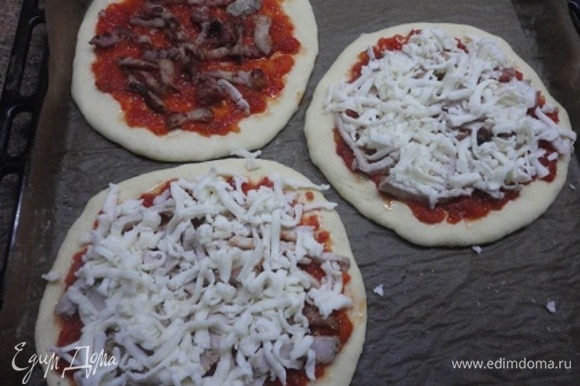 Тонко смазать поверхность каждой пиццы томатным соусом, оставляя чистым край теста. Сверху равномерно разложить бекон и накрыть все сыром моцарелла.