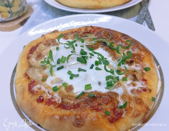 Поставить противень в разогретую духовку и печь до готовности, 10 минут, пока пицца почти полностью испечется. Достать противень с пиццами из духовки и разбить по одному яйцу на каждую. Осторожно поставить противень с пиццами назад в духовку и печь, пока яичный белок схватится. Достать пиццы к завтраку из духовки, приправить сверху солью и черным свежемолотым перцем и посыпать зеленью. Подавать к завтраку сразу же!