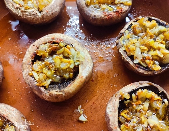 Выложить лук с ножками в шляпки шампиньонов.