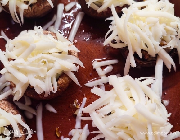 Сулугуни натереть на крупной терке и посыпать сверху шляпки. Запекать в духовке минут 5 (пока сыр не расплавится и немного не подрумянится).