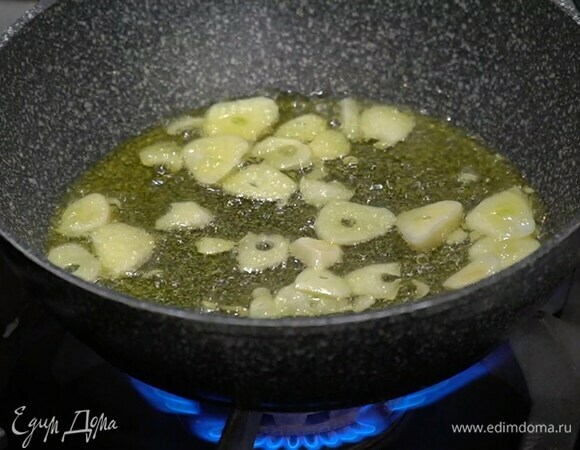 Приготовить чесночную заправку: чеснок почистить, нарезать тонкими пластинками и обжаривать на разогретом в тяжелой сковороде оливковом масле, помешивая, чтобы не горел, до золотистого цвета. Затем чеснок выложить на бумажное полотенце.