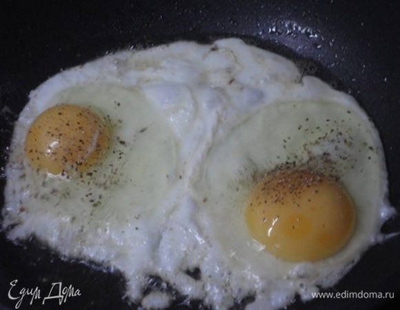 Грудинку обжарить на сковороде и отложить на тарелку. В эту же сковороду разбить два яйца, поперчить и жарить на небольшом огне, пока не затвердеет белок.