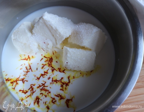 В молоко поместить размягченное сливочное масло, сахар, соль и шафран, нагреть до горячего состояния, не кипятить (это нужно, чтобы нити шафрана отдали свой цвет). Снять с огня, дать остыть до температуры тела, добавить сухие дрожжи. Дать постоять 5 минут.